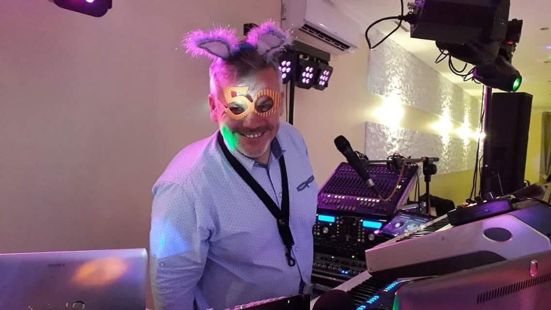 Uśmiechnięty Wojtek za instrumentami podczas imprezy