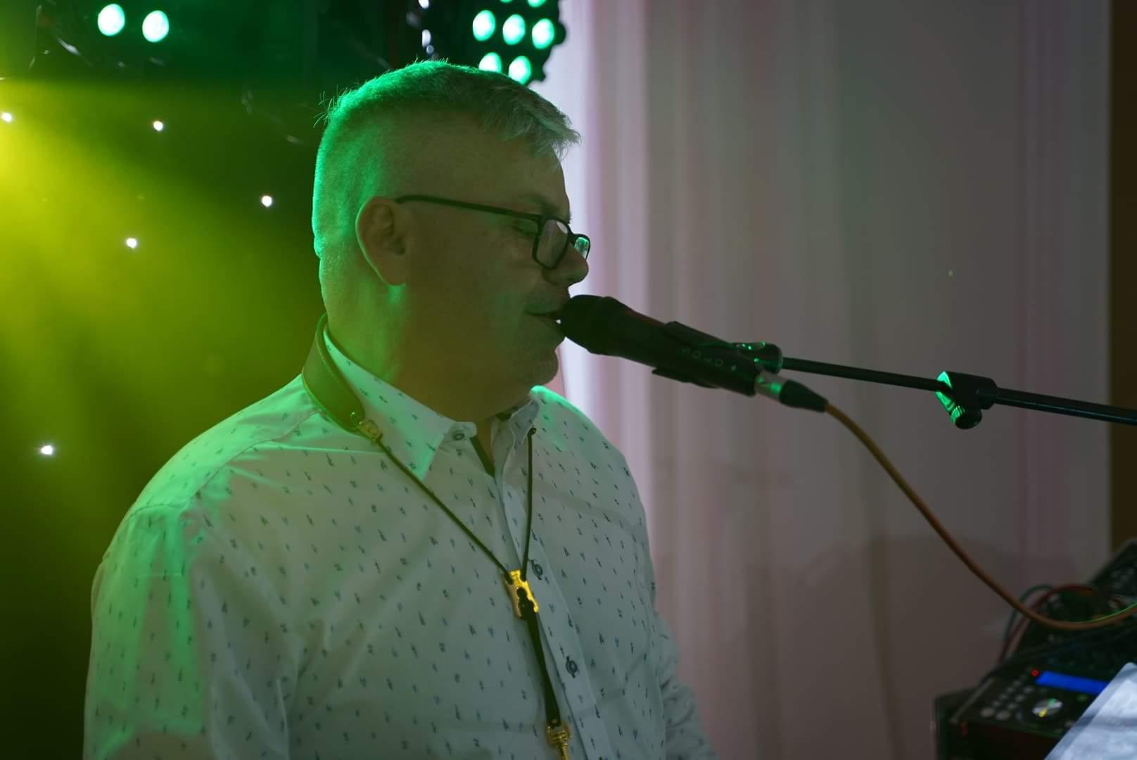Wojtek śpiewa do mikrofonu podczas występu